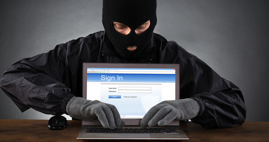 Hacker Hacking Account Of Social Networking Site On Laptop At Desk
